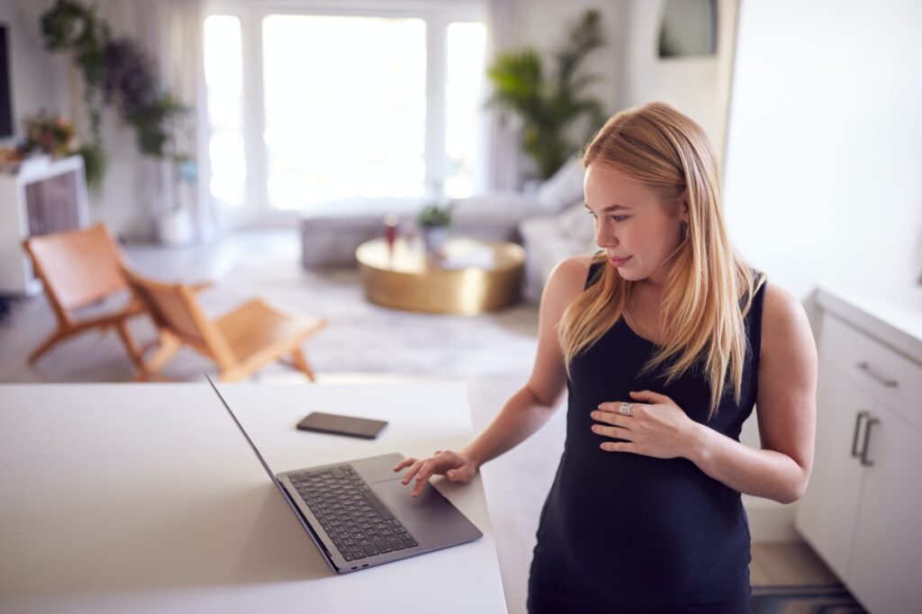 Pregnant woman working from home on laptop