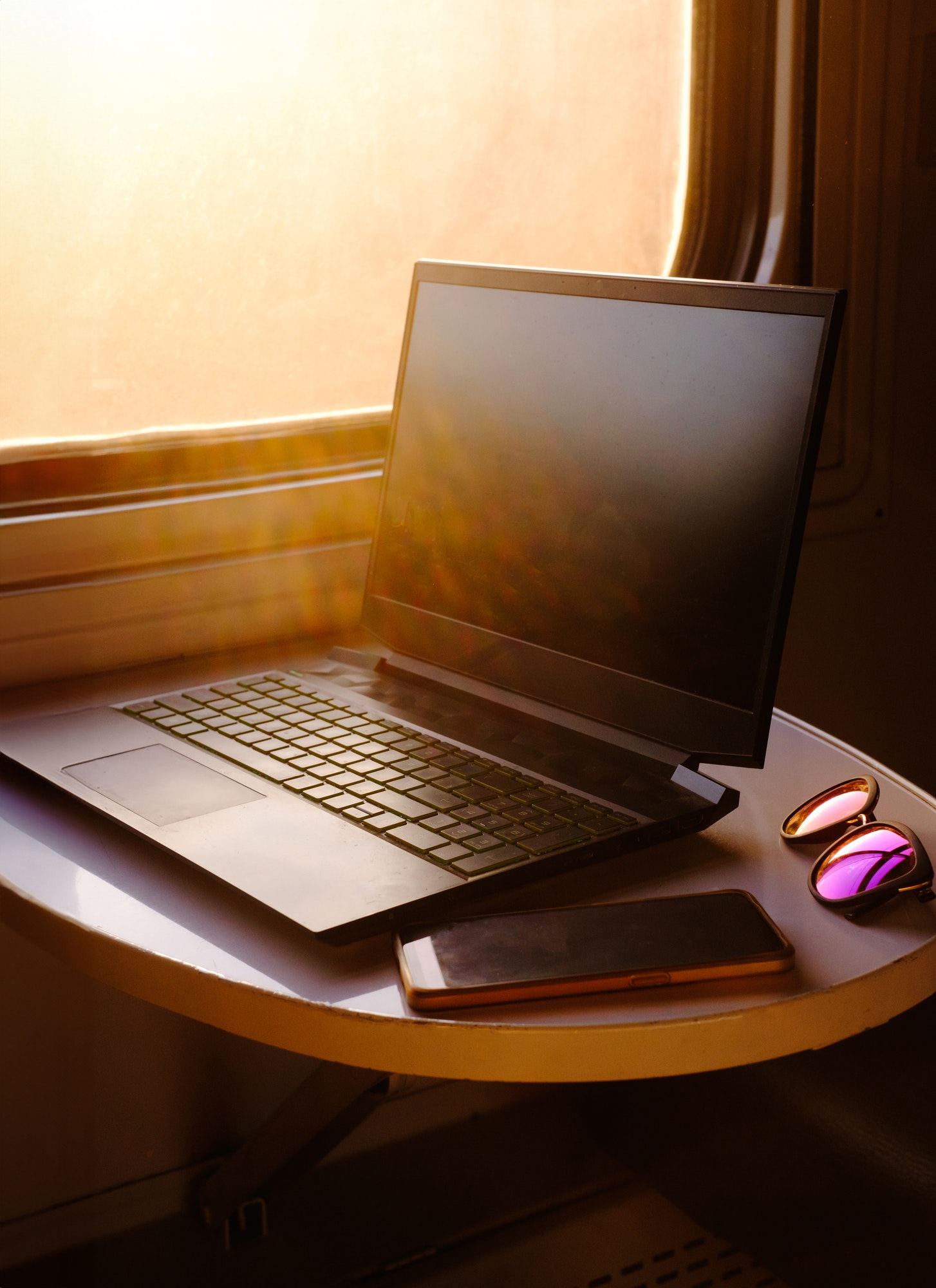 Laptop in train on the table by the window. Business trip
